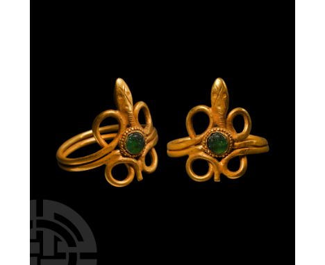 Roman Period, 30 B.C.-323 A.D. or later. The hoop a double-coil with lateral loops, lentoid head, applied cell with beaded wi