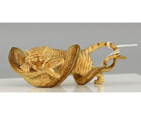 Early 20th century Indian carved ivory group of a tiger wrestling a snake, with gilt painted highlights, 14cm long,PLEASE NOT