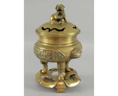 Chinese brass censer and cover on stand, the pierced cover with temple lion finial, on three supports and lily pad base, 24cm
