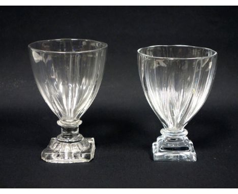 Two late Georgian rummers with vertical ribbing, the taller with capstan stem on a square moulded lemon squeezer foot, untrim