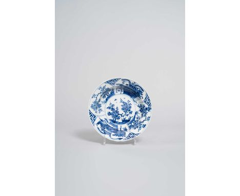 A CHINESE BLUE AND WHITE DISH KANGXI 1662-1722  The deep body painted to the well with flowering prunus and butterflies, the 