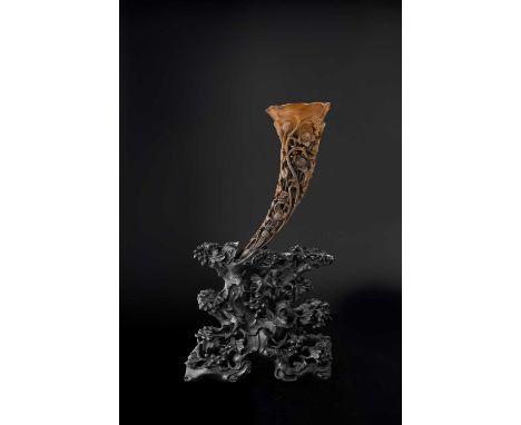 λ A CHINESE FULL-TIP RHINOCEROS HORN LIBATION CUP AND STAND 19TH CENTURY  The stem intricately carved in high relief and open