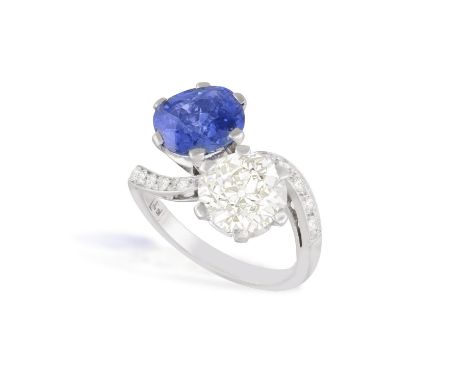AN EARLY 20TH CENTURY SAPPHIRE AND DIAMOND 'TOI ET MOI' DRESS RINGObliquely-set with an old cushion-shaped diamond weighing a
