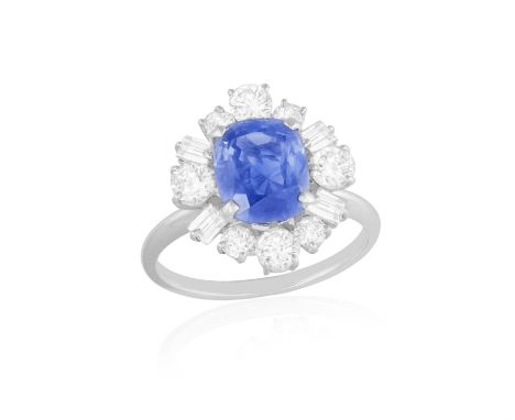 A SAPPHIRE AND DIAMOND CLUSTER RINGThe cushion-shaped sapphire weighing approximately 3.50cts, within a step and brilliant-cu