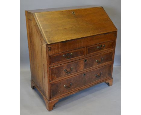 A George II Walnut and Oak Bureau, the fall front enclosing a fitted interior with well above two short and two long drawers 