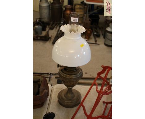 A brass oil lamp with opaque glass shade 