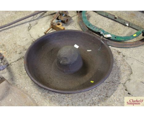 A circular cast iron pig trough