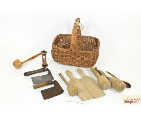 A wicker basket containing various vintage kitchen items including choppers, butter pats, sand timer etc.