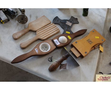 A wooden and ceramic lemon squeezer, a dough scraper, a pair of butter pats, a wooden tie press and a gas saving plate 