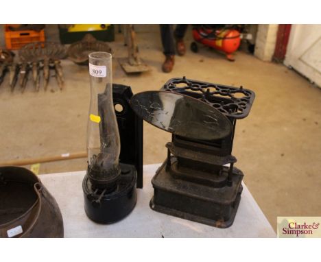 A metal ware wall mounting oil lamp and a small oil stove by Kenrick &amp; Co.