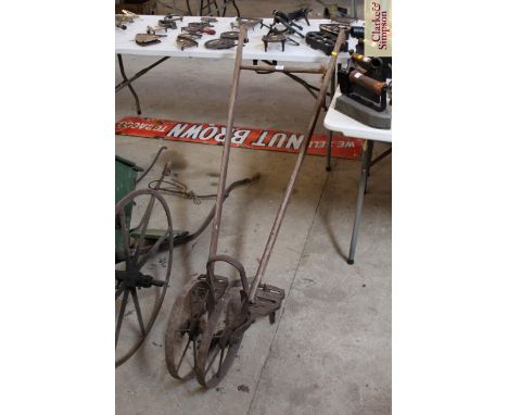 A push hoe with pair of metal wheels and spanner