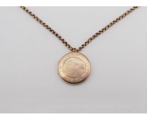 A circular 9ct gold Locket with engine turning and monogram engraved to reverse on chain marked 9C, approx 12.50gms all in