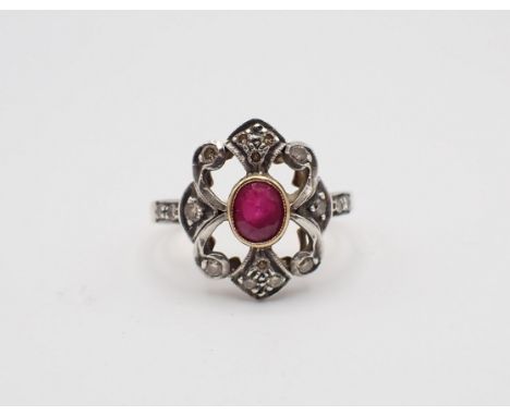 A Ruby and Diamond Cluster Ring rubover-set oval-cut ruby within openwork frame set brilliant-cut diamonds, stamped 750, ring