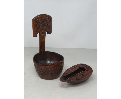 A carved treen Feeding Cup with shaped spout with carved tulip designs and the word 'RIGI', the underside with carved shell d