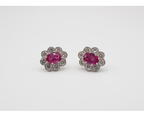 A pair of Ruby and Diamond Cluster Earrings each claw-set oval-cut ruby within frame of eight millegrain-set brilliant-cut di