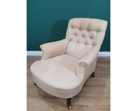 A Howard and Sons deep seated button back upholstered Armchair, with square tapered front supports and castors, rear left leg