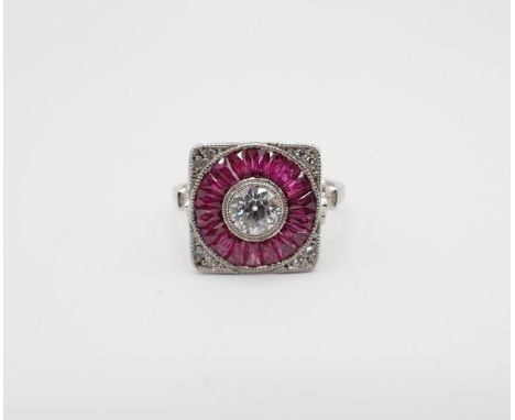 An Art Deco style Diamond and Ruby Target Ring millegrain-set old-cut diamond within a round frame of faceted tapered baguett