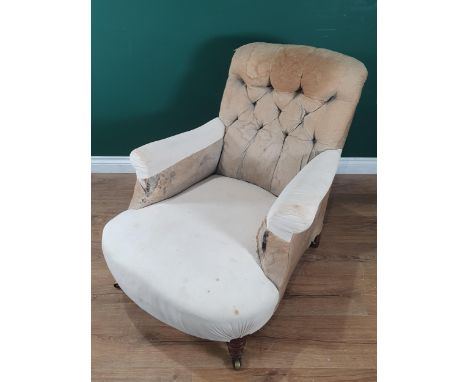 A Howard and Sons deep seated button back Easy Chair, on turned front supports and castors, rear left leg impressed 'Howard a