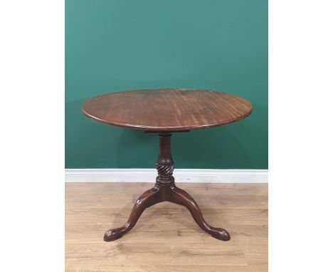 A George II mahogany Supper Table with circular top on turned and fluted column, the tripod base with carved knees on pad fee