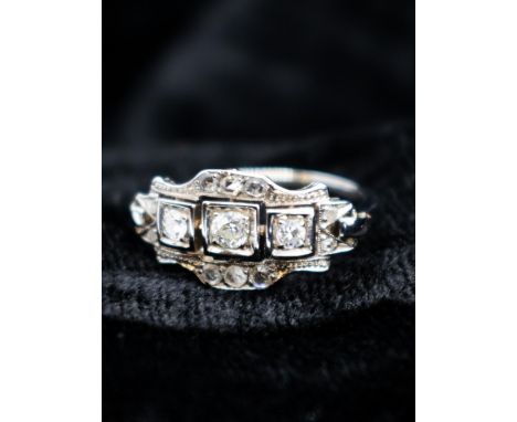 An Art Deco style Diamond Ring pavé-set three graduated principle old and brilliant-cut stones within openwork frame set smal