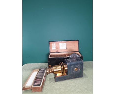 A brass and painted tin Magic Lantern in box with a case of magic lantern slides 