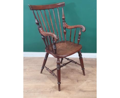 A 19th Century mahogany Windsor Elbow Chair with comb and stick back raised on turned supports united by H-stretcher 3ft 4in 