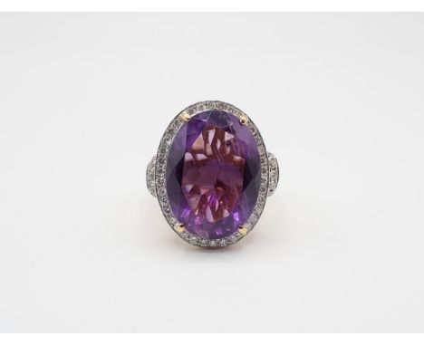 An Amethyst and Diamond Cluster Ring claw-set oval-cut amethyst within a frame of pavé-set brilliant-cut diamonds, stamped 75