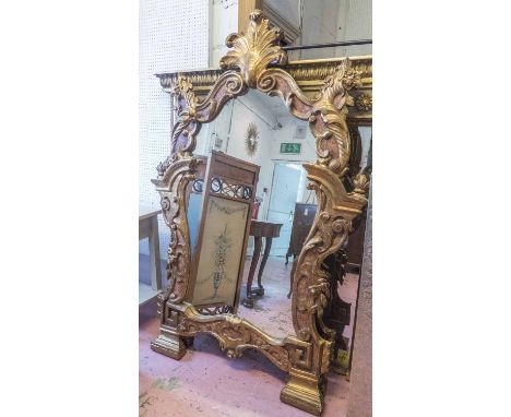 MIRRORS, a pair, late 19th/early 20th century Italian giltwood, the surround carved with architectural, foliate, rockwork and