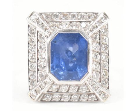 A French 18ct white gold, sapphire and diamond dress ring. The ring having a rectangular head with a central emerald cut sapp