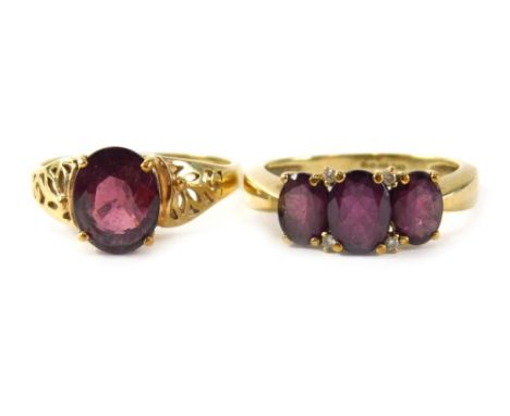 Two 9ct gold dress rings, comprising a garnet three stone ring, ring size S½, and a garnet single stone with Celtic design sh