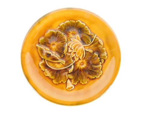 A Linthorpe pottery plate, with Christopher Dresser signature mark, raised with flowers no. 622, impressed marks beneath, 24c