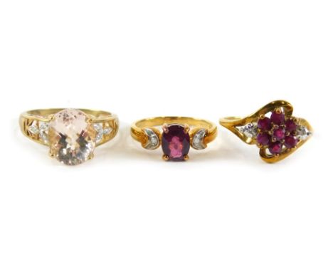 Three dress rings, comprising a 9ct gold garnet and cz three stone ring, ring size N½, a 9ct gold garnet and cz set floral tw