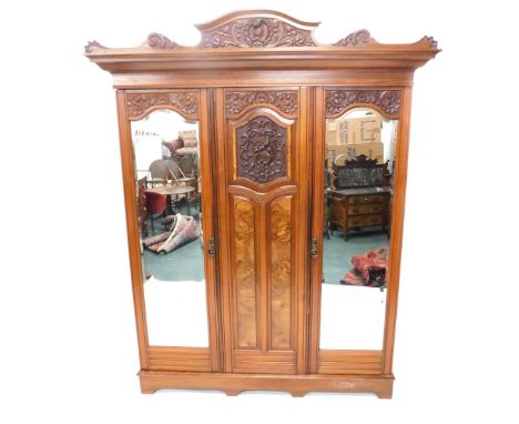 A late 19th/early 20thC walnut and figured walnut bedroom suite, comprising triple wardrobe with scroll carved detail, two be