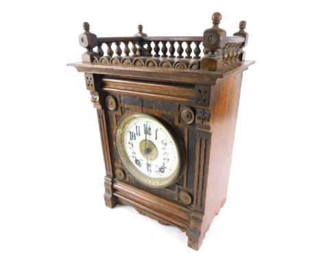 An early 20thC oak mantel clock, with a three part galleried top raised above 14cm diameter Arabic dial, with a heavily carve