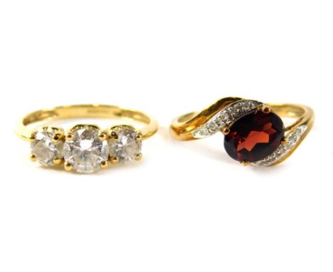 Two 9ct gold dress rings, comprising a cz three stone cluster, ring size R, and a red spinal twist ring, ring size S, 6.3g al