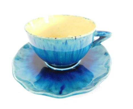 A Linthorpe pottery tea cup and saucer, in turquoise and blue glazes, the cup with angular handle, 5cm high, each numbered 14