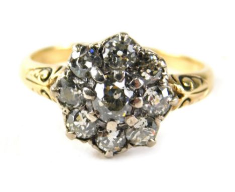 A Victorian dress ring, set with a floral cluster of tiny diamonds, on yellow metal scroll shoulders, unmarked, believed to b