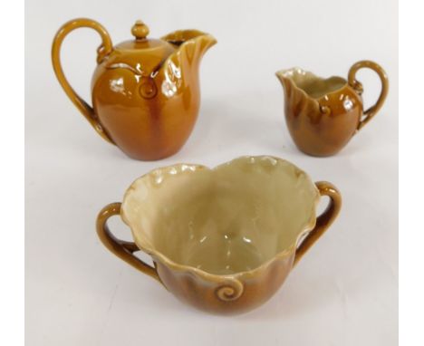 A Linthorpe pottery three piece tea service, comprising teapot, two handled sugar bowl and milk jug, no. 1039, 10cm high, eac