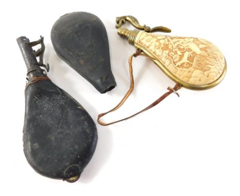 A leather powder flask, of teardrop form, with iron top, 20cm high, a resin and brass powder flask heavily decorated with hun