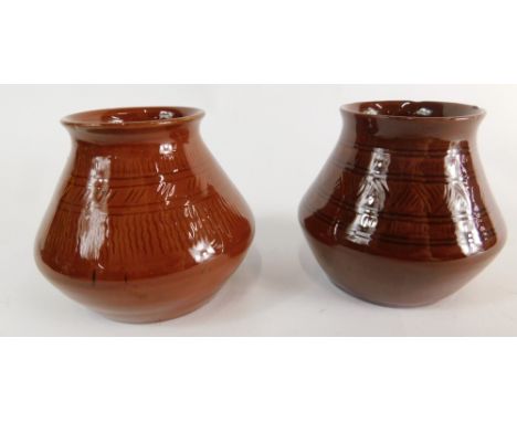 A matched pair of Linthorpe pottery vases, one initialled AW with script mark beneath of bellied circular form, in brown glaz