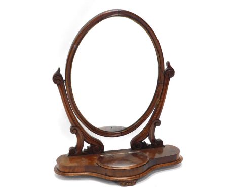 A Victorian mahogany dressing table mirror, with oval plate, on pierced, moulded and shaped supports, the base with a central