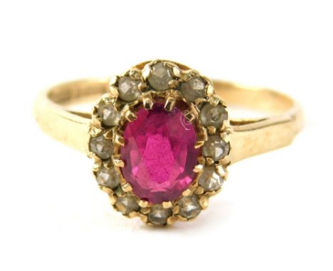 A 9ct gold garnet and cz cluster ring, the oval garnet surrounded by cz in claw setting on a yellow metal band with V splayed