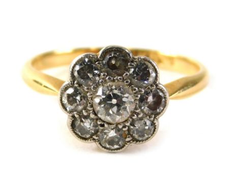A diamond floral cluster ring, the daisy set with central old cut diamond approximately 0.12 carats, surrounded by eight tiny