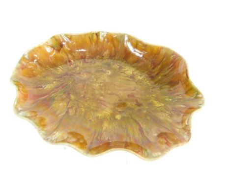 A Linthorpe pottery dish, with shaped rim in mottled glazes of red and green, no.1275, impressed marks beneath, 31cm wide.