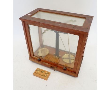 A set of brass chemical balance scales in glass case with set of weights, by Phillip Harris Ltd. 35.5cm tall 