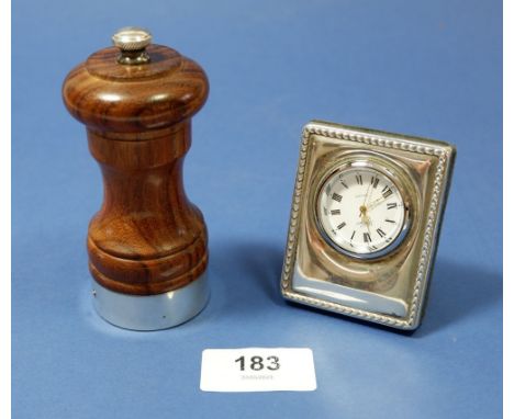 A silver mounted wooden pepper grinder and a silver mounted clock 