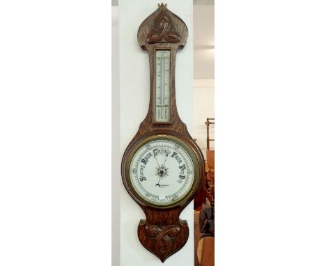 An oak barometer/thermometer by H Hughes and Son Ltd. 69cm tall 