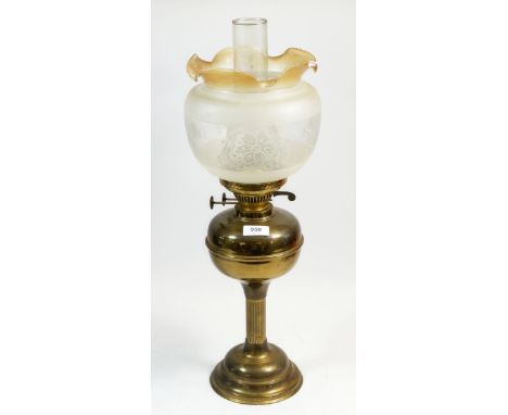 A brass oil lamp with etched and frilled glass shade 