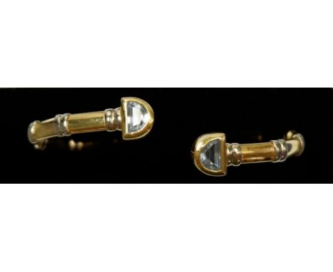 An 18 carat gold open bangle set two aquamarines to terminals and white metal banding, 13.9g 