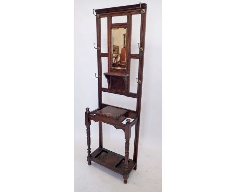 An Edwardian oak hall stand with brass hooks, mirror, glove box and stick stands, 197cm tall 